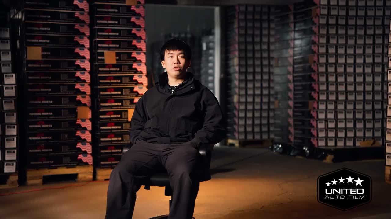 A member of the United Auto Film team seated in the company's warehouse, from the brand documentary we shot